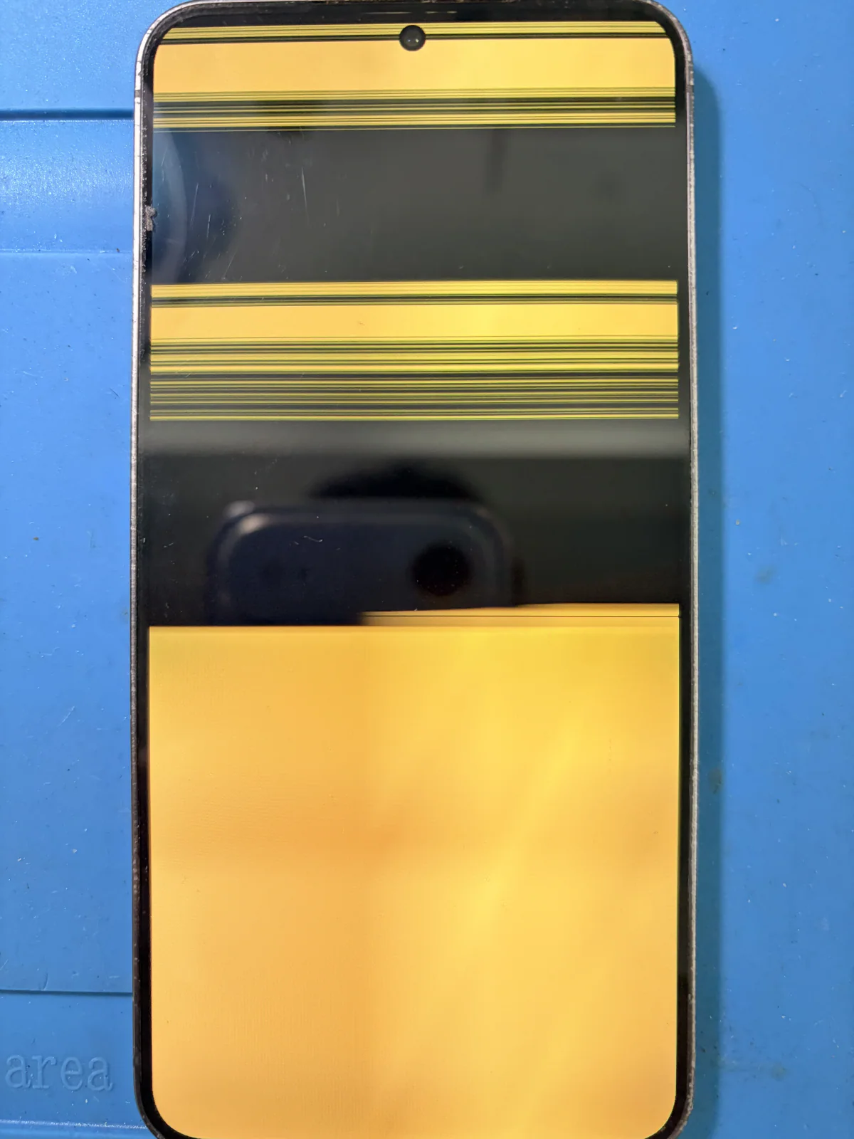 Galaxy S24 before screen replacement showing yellow banding and horizontal line damage
