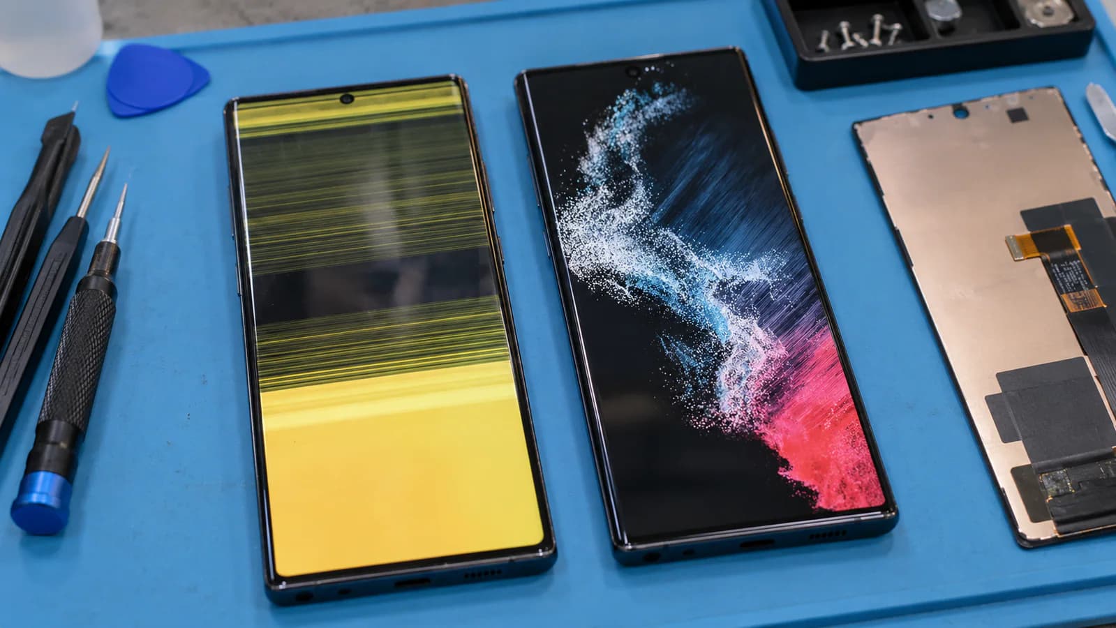 Samsung Galaxy S phones on a repair bench showing a damaged display, working display and screen assembly